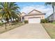 Inviting home with a two-car garage, long driveway, well manicured lawn and tropical landscaping at 4724 Sable Ridge Ct, Leesburg, FL 34748