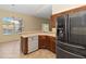 Kitchen featuring wood cabinets, stainless steel refrigerator, tile flooring, and a dishwasher at 4724 Sable Ridge Ct, Leesburg, FL 34748