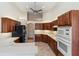 Well-lit kitchen with wooden cabinets, white countertops, and stainless steel appliances at 4724 Sable Ridge Ct, Leesburg, FL 34748