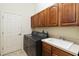 Spacious laundry room with appliances, sink, cabinets, and access door at 4724 Sable Ridge Ct, Leesburg, FL 34748