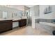 Modern bathroom with dual vanity, walk-in glass shower, and soaking tub at 4796 Riverwalk Dr, St Cloud, FL 34771