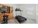 Dedicated exercise room with treadmill, stationary bike, and storage cabinet at 4796 Riverwalk Dr, St Cloud, FL 34771