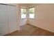 A sunlit bedroom featuring two windows, neutral carpeting, and a closet with white doors at 4852 Blue Major Dr, Windermere, FL 34786