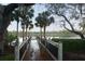 A wooden pier extending into a lake, framed by palm trees and lush greenery at 4852 Blue Major Dr, Windermere, FL 34786