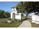 Elegant community entrance featuring lush landscaping, decorative architecture, and a scenic lake view at 4852 Blue Major Dr, Windermere, FL 34786