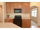 Bright kitchen featuring wood cabinets, black appliances, and a view into the living area at 4852 Blue Major Dr, Windermere, FL 34786