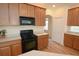 Kitchen featuring wood cabinets, black appliances, and wood flooring at 4852 Blue Major Dr, Windermere, FL 34786