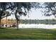 Scenic lake view with a wooden dock surrounded by green space and lush trees at 4852 Blue Major Dr, Windermere, FL 34786