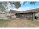 Backyard showcasing the enclosed patio and outdoor dining area with mature trees at 5444 Lighthouse Rd, Orlando, FL 32808