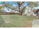 Lush backyard featuring a mature tree, fenced perimeter, and seating area at 5444 Lighthouse Rd, Orlando, FL 32808
