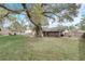 Spacious backyard featuring a large tree, patio area, and fenced boundary at 5444 Lighthouse Rd, Orlando, FL 32808