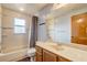 Bright bathroom with a tub-shower combination, large mirror, and wooden vanity at 5444 Lighthouse Rd, Orlando, FL 32808