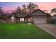 Beautiful single-story brick home with lush lawn, showcasing a warm and inviting facade at dusk at 5444 Lighthouse Rd, Orlando, FL 32808