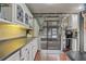 Galley style kitchen featuring white cabinets, black countertops, and a sliding glass door at 5444 Lighthouse Rd, Orlando, FL 32808