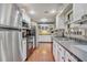 Galley kitchen with stainless appliances, white cabinetry, offers ample counter space and is well-lit at 5444 Lighthouse Rd, Orlando, FL 32808
