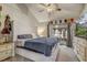 The bright primary bedroom features a ceiling fan, large bed, dresser, and a view of the screen patio at 5444 Lighthouse Rd, Orlando, FL 32808