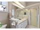 Bathroom with double sinks, large mirror, and walk-in shower with glass doors at 5676 Gulf Stream St, Tavares, FL 32778