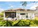 Rear exterior of the home with a screened lanai, well-manicured lawn and tidy landscaping at 5676 Gulf Stream St, Tavares, FL 32778