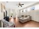 Bright living room featuring hardwood floors, modern ceiling fan, and large windows with sheer curtains at 5676 Gulf Stream St, Tavares, FL 32778