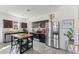 This well-lit kitchen features stainless steel appliances, dark cabinets, an island, and modern wood-look flooring at 5841 Bullock Pl, St Cloud, FL 34771