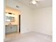 Neutral bedroom featuring carpet and ceiling fan, adjacent to a well-lit bathroom at 609 Gallery Dr # 2, Winter Park, FL 32792