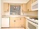 Kitchen featuring light wood cabinets, a white dishwasher, a double basin sink, and tiled floor with view into living space at 609 Gallery Dr # 2, Winter Park, FL 32792