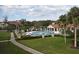 Community pool and clubhouse with lush landscaping and palm trees for a resort style living at 609 Gallery Dr # 2, Winter Park, FL 32792