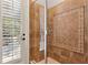 Elegant shower with decorative tile, glass door, and outdoor access with wood shutter at 6424 Cartmel Ln, Windermere, FL 34786