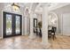 Dining room features elegant columns, travertine floors, and wrought iron double-door entry at 6424 Cartmel Ln, Windermere, FL 34786