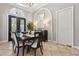 Dining room with travertine tile, wrought iron-accented doors, columns, and sophisticated decor at 6424 Cartmel Ln, Windermere, FL 34786