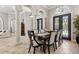 Dining area featuring travertine flooring, decorative columns, and wrought iron double doors at 6424 Cartmel Ln, Windermere, FL 34786