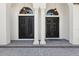 Detailed view of the home's double front doors, framed by elegant columns and brick pavers at 6424 Cartmel Ln, Windermere, FL 34786