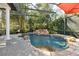 A beautiful screened-in pool with a rock waterfall feature and lush landscaping, creating a private oasis at 6424 Cartmel Ln, Windermere, FL 34786