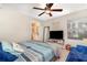 Comfortable bedroom with ceiling fan, accent mirror, television, and bathroom access at 729 Secret Harbor Ln # 105, Lake Mary, FL 32746