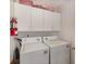 Practical laundry area with washer, dryer, and overhead cabinets at 729 Secret Harbor Ln # 105, Lake Mary, FL 32746