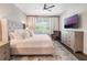 Comfortable bedroom featuring a tufted headboard, hardwood floors, and drapes at 753 Daybreak Pl, Longwood, FL 32750