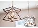 A close up view of a modern, geometric chandelier with bronze and dark metal finishes at 753 Daybreak Pl, Longwood, FL 32750