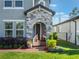 Close up of the front entrance featuring a decorative stone facade, potted plants, and a brick walkway at 753 Daybreak Pl, Longwood, FL 32750