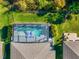 Aerial view of a screened-in pool with blue loungers in a backyard with lush landscaping and a black fence at 753 Daybreak Pl, Longwood, FL 32750