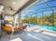 Relaxing screened pool with outdoor seating, ceiling fan, a grill and view of the lush green landscape at 753 Daybreak Pl, Longwood, FL 32750