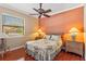 Bedroom featuring a ceiling fan, hardwood floors, and a window overlooking the neighborhood at 755 Country Charm Cir, Oviedo, FL 32765