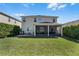 Home exterior with a covered patio, manicured lawn, and second-story windows at 8066 Bowery Dr, Winter Garden, FL 34787