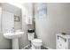 Cozy powder room with pedestal sink, patterned tile floor, and a modern white cabinet at 8066 Bowery Dr, Winter Garden, FL 34787