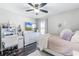 Cozy bedroom with plush rug, ceiling fan, white desk, and decorative accents at 8066 Bowery Dr, Winter Garden, FL 34787