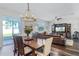 Cozy dining area with stylish lighting, hardwood floors, and a seamless connection to the living room and outdoor patio at 8066 Bowery Dr, Winter Garden, FL 34787