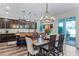 Bright dining room with dark wood table and chairs, modern lighting, and sliding glass doors to patio at 8066 Bowery Dr, Winter Garden, FL 34787