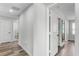 Upstairs hallway featuring wood-look floors and access to rooms at 8066 Bowery Dr, Winter Garden, FL 34787