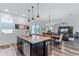 Well-lit kitchen featuring a granite island and breakfast bar, seamlessly connecting to the dining and living areas at 8066 Bowery Dr, Winter Garden, FL 34787