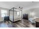 Bright main bedroom featuring a four-poster bed, ceiling fan, and wood-look floors at 8066 Bowery Dr, Winter Garden, FL 34787