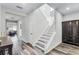 Bright foyer features wood-look flooring, a staircase with white railing, and a stylish decorative clock at 8066 Bowery Dr, Winter Garden, FL 34787